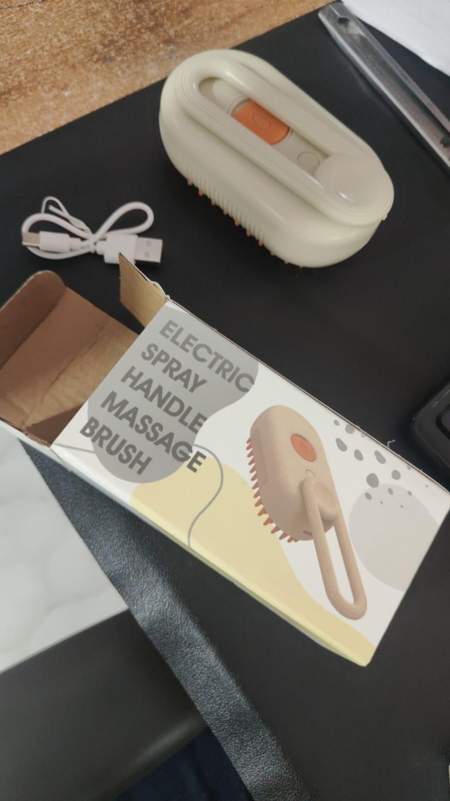 Electric spray handle massage brush with packaging on a dark surface